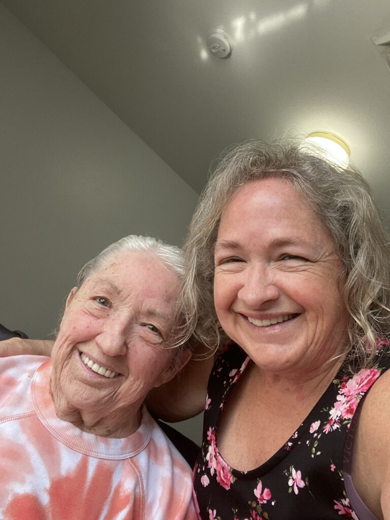 Amy and her mom smiling close together looking at the camera 