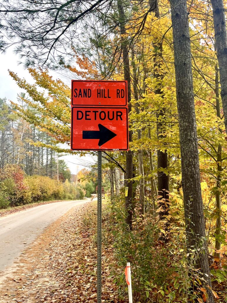 Detour sign along a country road with autumn leaves 