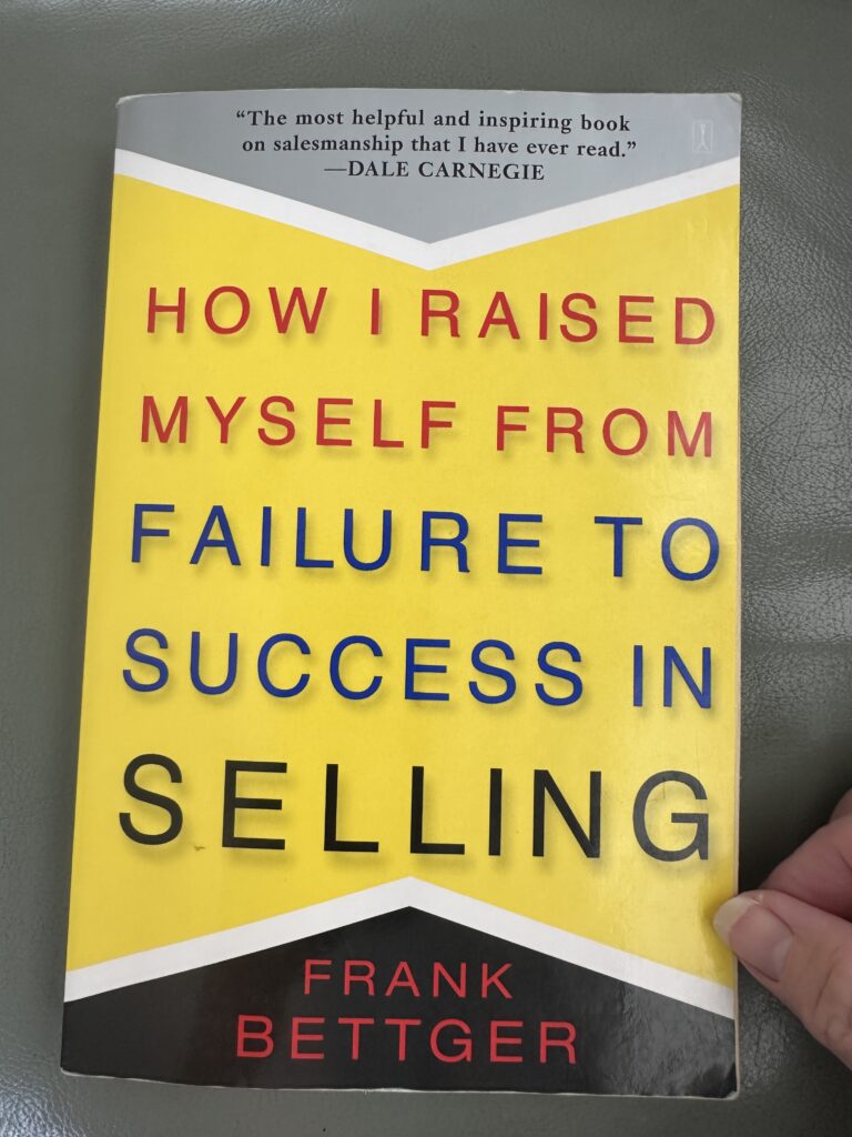 How I Raised Myself From Failure to Success in Selling book laying on an armrest. 